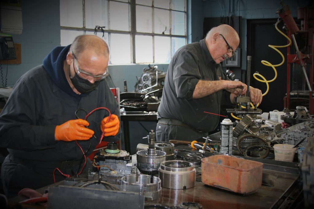 Two employees working on repairing car parts